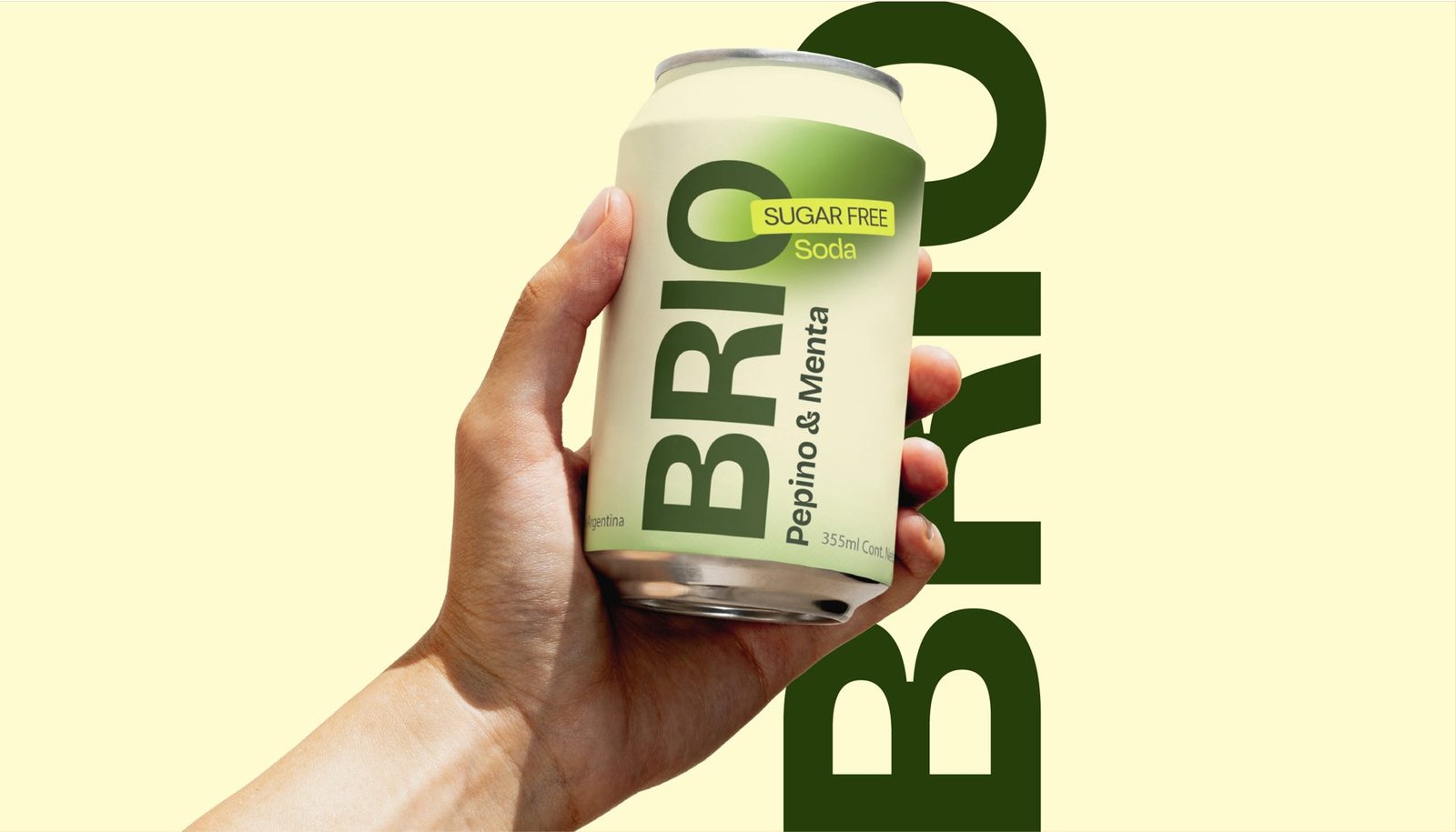 Lata de Brio pepino y menta en la mano sobre fondo crema con el logotipo en grande