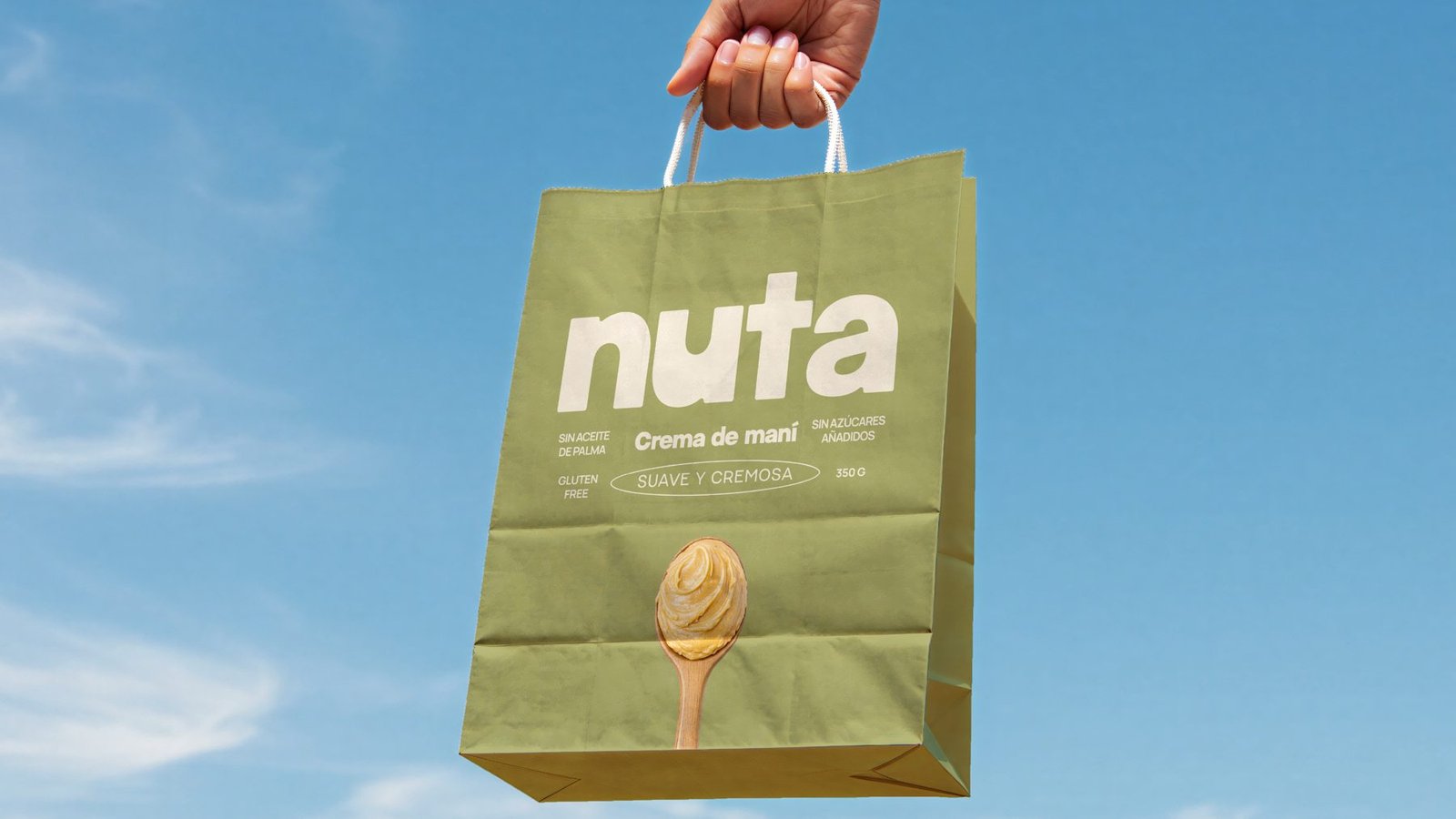Bolsa de papel verde de Nuta sostenida contra el cielo